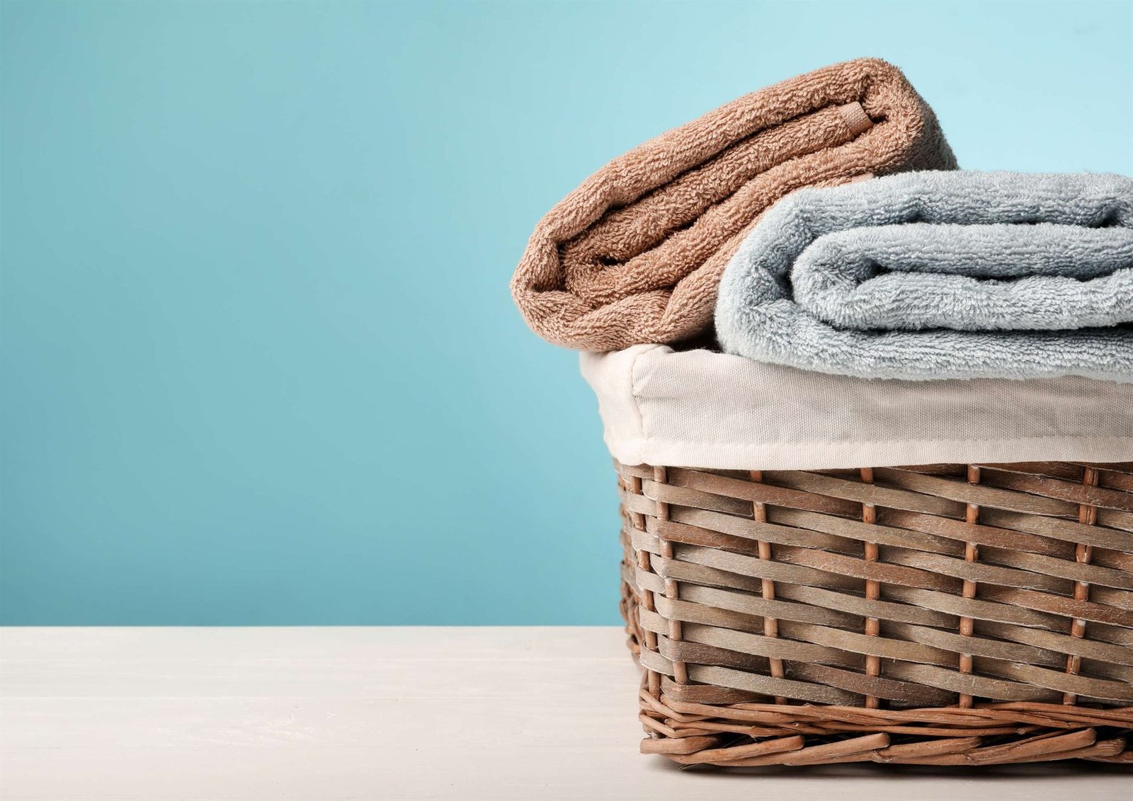 Linge propre plié dans un panier en osier — blanchisserie Le Blanc Lémanique à Saint-Julien-en-Genevois